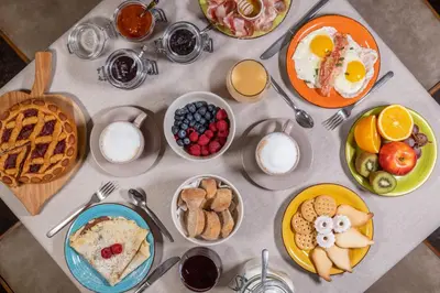 a table topped with plates of breakfast foods at Agritur Broch in Fiera di Primiero