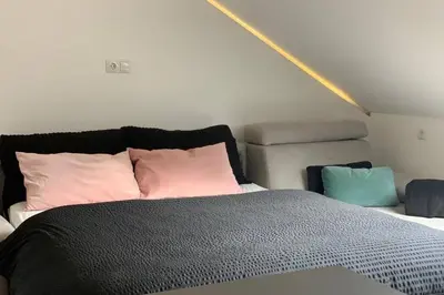 a bedroom with a bed with pink and blue pillows at Apartment Marie in Bolzano