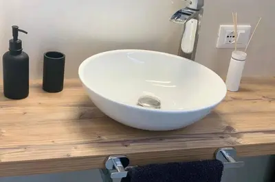 a white sink sitting on top of a wooden counter at Apartment Marie in Bolzano