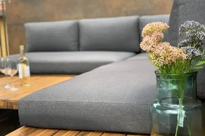 a vase of flowers on a table next to a couch at Apartment Marie in Bolzano