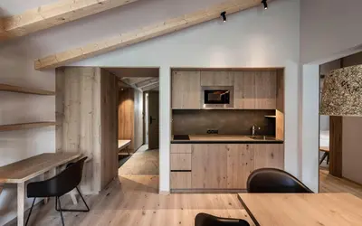 a kitchen and dining room with a table and chairs at Residence Le Fostü in San Vigilio Di Marebbe