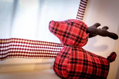 a stuffed teddy bear sitting in front of a window at Majon Viva in Campitello di Fassa