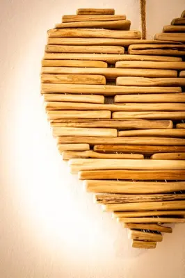 a heart made out of logs on a wall at Majon Viva in Campitello di Fassa