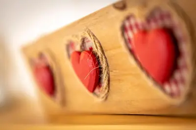 a wooden box with three red hearts in it at Majon Viva in Campitello di Fassa