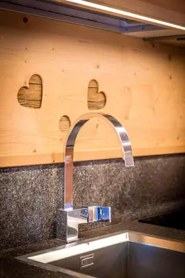 a kitchen sink with two hearts on the wall at Majon Viva in Campitello di Fassa