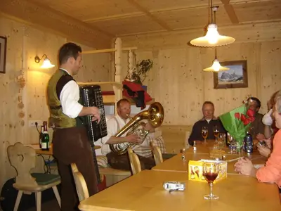 a man playing a accordion and a band in a restaurant at Binterhof in Castelrotto