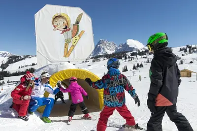 a group of people standing in the snow with a snowboard at Binterhof in Castelrotto