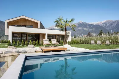 a house with a swimming pool in front of a house at Das Heacher in Merano