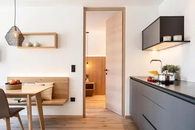 a kitchen and dining room with a table and a door at Das Heacher in Merano