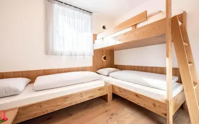 two bunk beds in a room with a window at Das Heacher in Merano