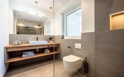 a bathroom with a toilet and a sink and a mirror at Das Heacher in Merano