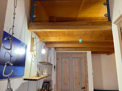 a room with a wooden ceiling and a door at Cèsa MeSa in Canazei