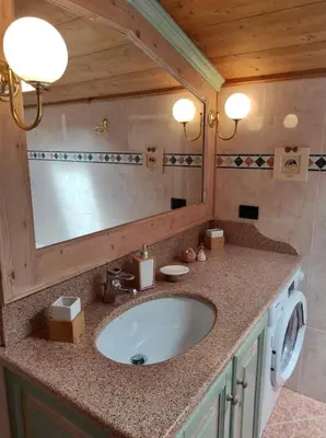 a bathroom with a sink and a washing machine at Cèsa MeSa in Canazei