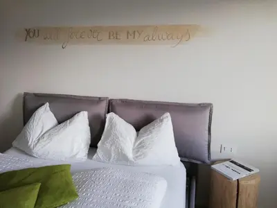 a bedroom with a bed with a sign on the wall at Casa Lassù in Carano