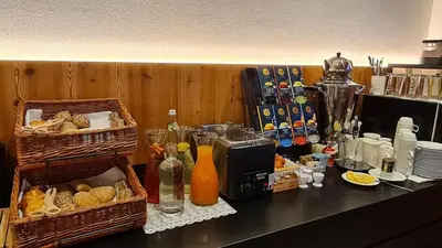 a counter with baskets of bread and drinks on it at Residence Altea in Ortisei