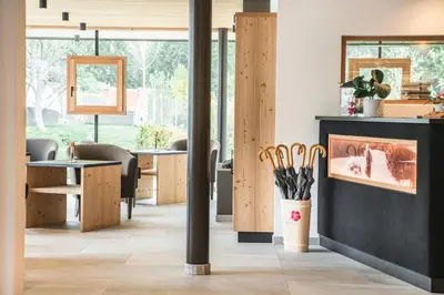 a room with a fireplace and tables and chairs at Residence Altea in Ortisei