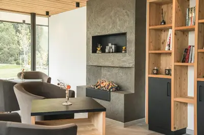 a living room with a fireplace and a table and chairs at Residence Altea in Ortisei