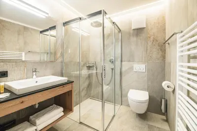 a bathroom with a shower and a toilet and a sink at Residence Altea in Ortisei