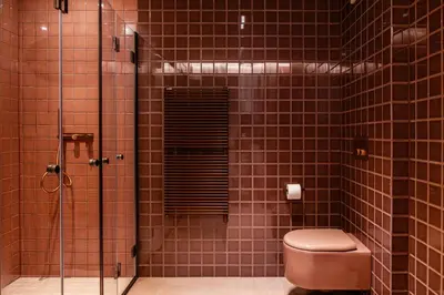 a bathroom with a toilet and a glass shower at Chalet Corvara in Corvara in Badia