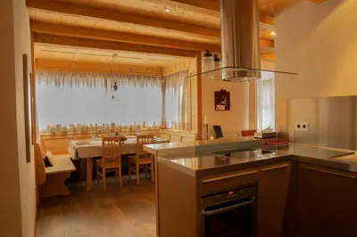 a kitchen with a table and a dining room at Chalet Corvara in Corvara in Badia
