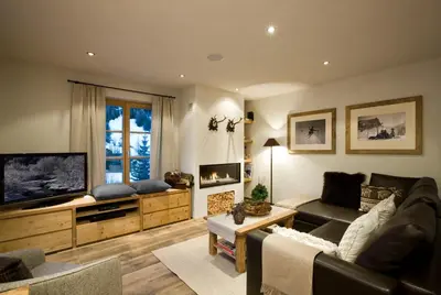 a living room with a couch and a flat screen tv at Chalet Corvara in Corvara in Badia