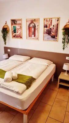 two beds in a room with pictures on the wall at B&B Maya in Merano