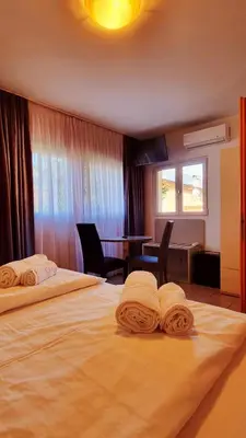 a hotel room with two beds with towels on them at B&B Maya in Merano