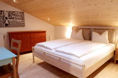 a bedroom with a bed and a table and a desk at Apartment Luam - Alpstay in Naturno