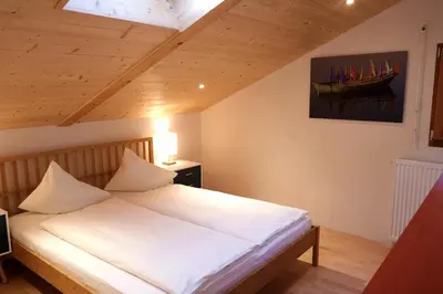 a bedroom with a white bed with a boat on the wall at Apartment Luam - Alpstay in Naturno