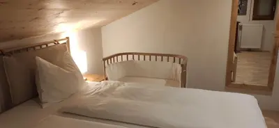 a bedroom with a bed with white sheets and a mirror at Apartment Luam - Alpstay in Naturno