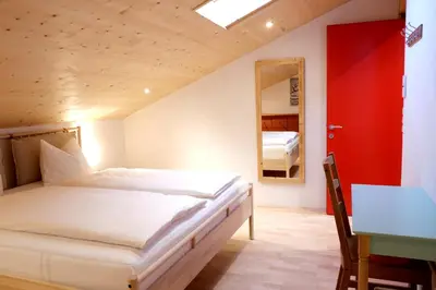 a bedroom with a bed and a table and a mirror at Apartment Luam - Alpstay in Naturno