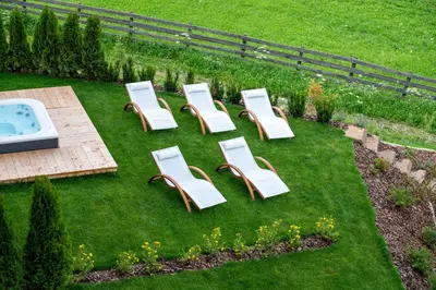 a group of chairs and a tub in a yard at CHALET NORA in San Vigilio Di Marebbe