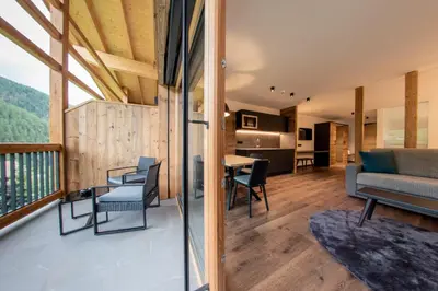 a large living room with a table and chairs at CHALET NORA in San Vigilio Di Marebbe