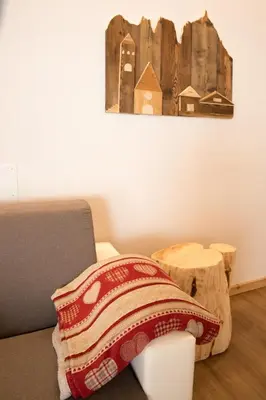 a bedroom with a bed and a painting on the wall at Latemar Fiemme Apartments in Tesero