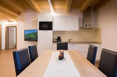 a dining room with a wooden table and chairs at Latemar Fiemme Apartments in Tesero