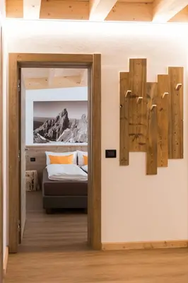 a bedroom with a bed and a mirror on the wall at Latemar Fiemme Apartments in Tesero