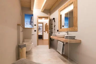 a bathroom with two sinks and a mirror at Latemar Fiemme Apartments in Tesero
