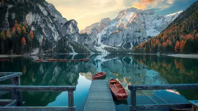 a dock with two boats on a lake with a mountain at Alpine Deluxe in Riscone