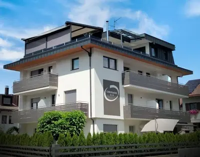 a white building with balconies on the side of it at Alpine Deluxe in Riscone