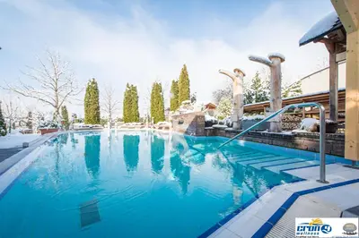a large swimming pool with blue water at Alpine Deluxe in Riscone
