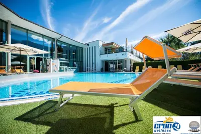 a swimming pool with a chair next to a house at Alpine Deluxe in Riscone