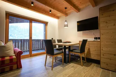 a bedroom with a bed and a flat screen tv at Lüch de Crusteles in La Valle