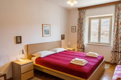 a bedroom with a large bed and a window at Arzenhof, Baron Di Pauli in Caldaro