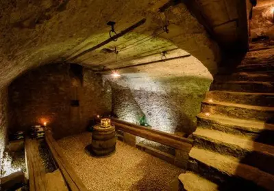 a tunnel with a barrel and stairs in a cave at Schwarzhaus in Monticolo