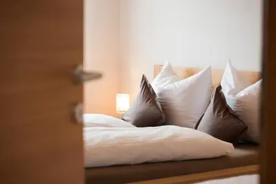 a bed with white pillows and a lamp on it at Schwarzhaus in Monticolo