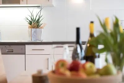 a counter with a bowl of fruit and bottles of wine at Schwarzhaus in Monticolo
