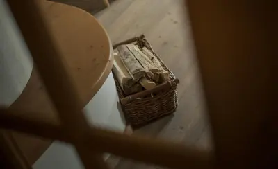 a basket of logs sitting on a wooden floor at Apartments Moarhof in Feldthurns