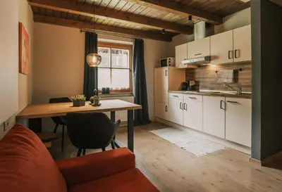 a kitchen with a table and a dining room at Apartments Moarhof in Feldthurns