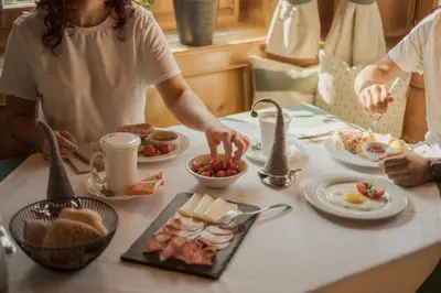 a group of people standing around a table with breakfast foods at Apartments Moarhof in Feldthurns