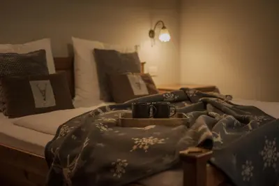 a bed with two mugs and a blanket on it at Apartments Moarhof in Feldthurns